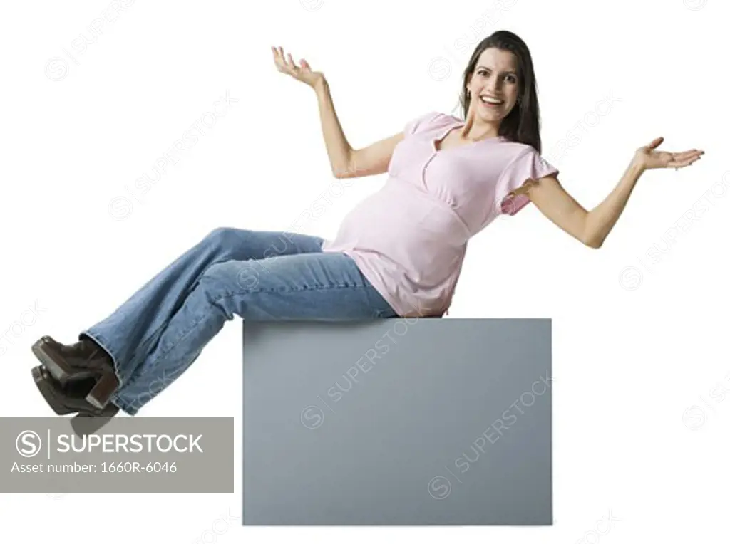 Portrait of a pregnant woman sitting on a blank sign
