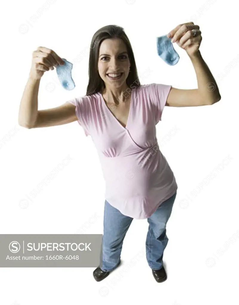 High angle view of a pregnant woman holding up baby socks