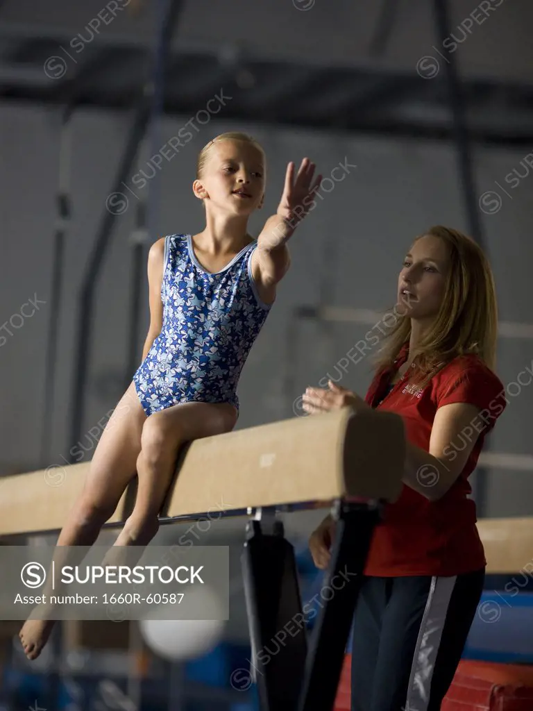 USA, Utah, Orem, girl (10-11) exercising on balance beam with teacher