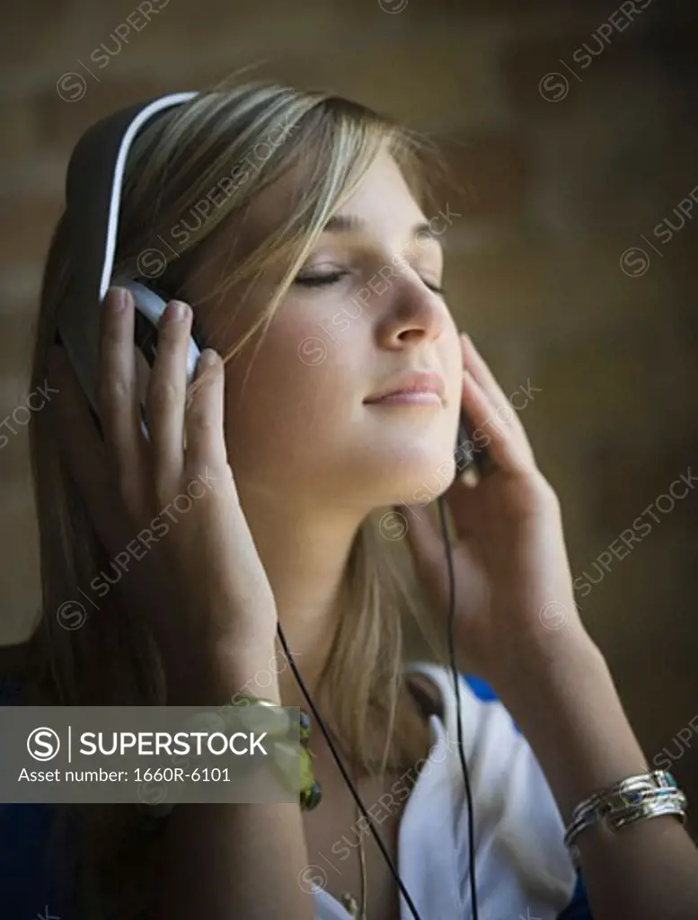 Teenage girl listening to music with her eyes closed