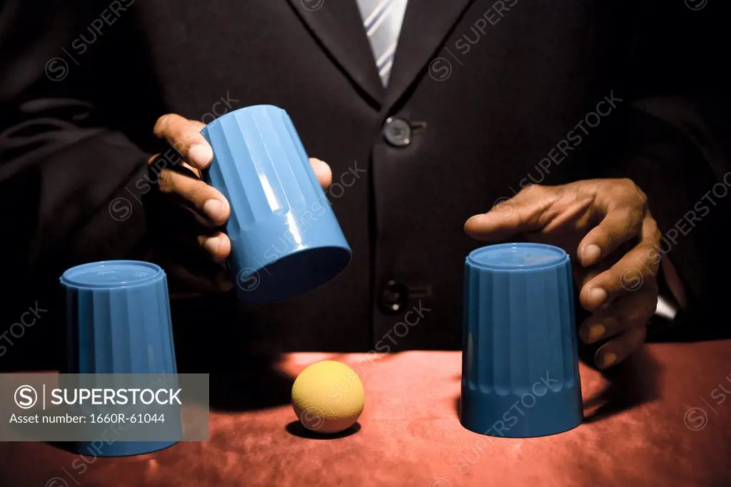 Man doing trick with three cups