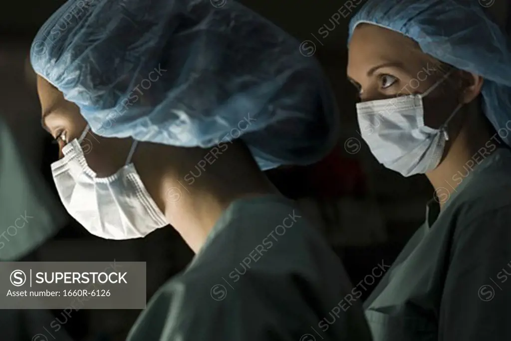 Profile of two surgeons in an operating room
