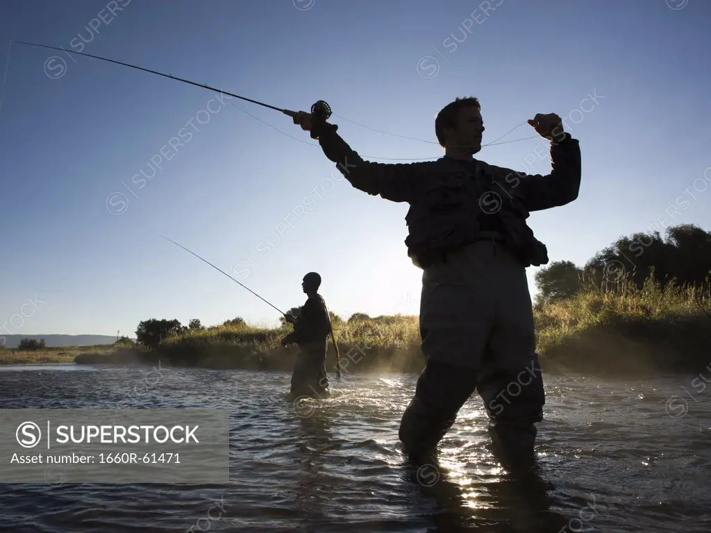 fly fisherman fishing in a mountain river