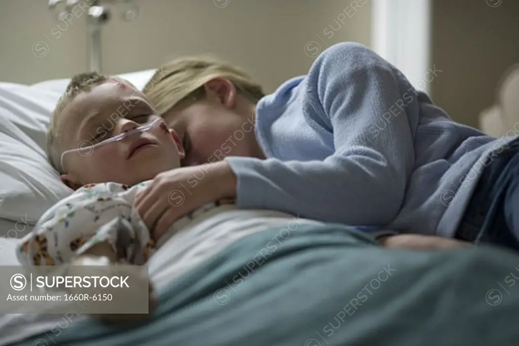 Sister sleeping with her brother on a hospital bed