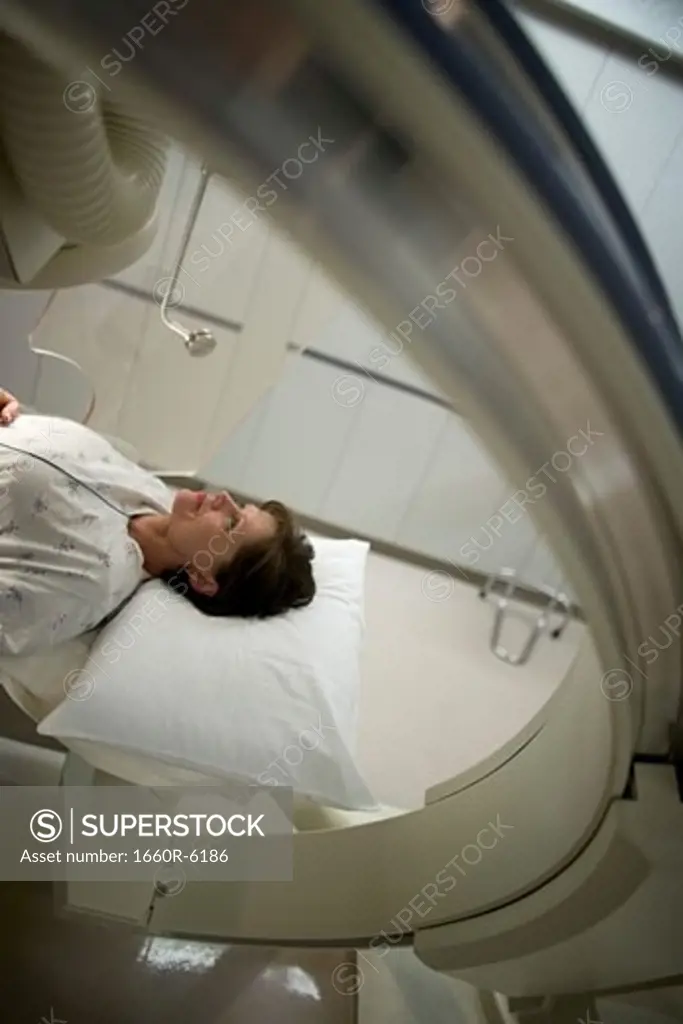 High angle view of a female patient lying under an X-Ray machine
