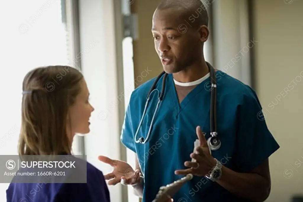 Close-up of a male doctor talking to a female doctor