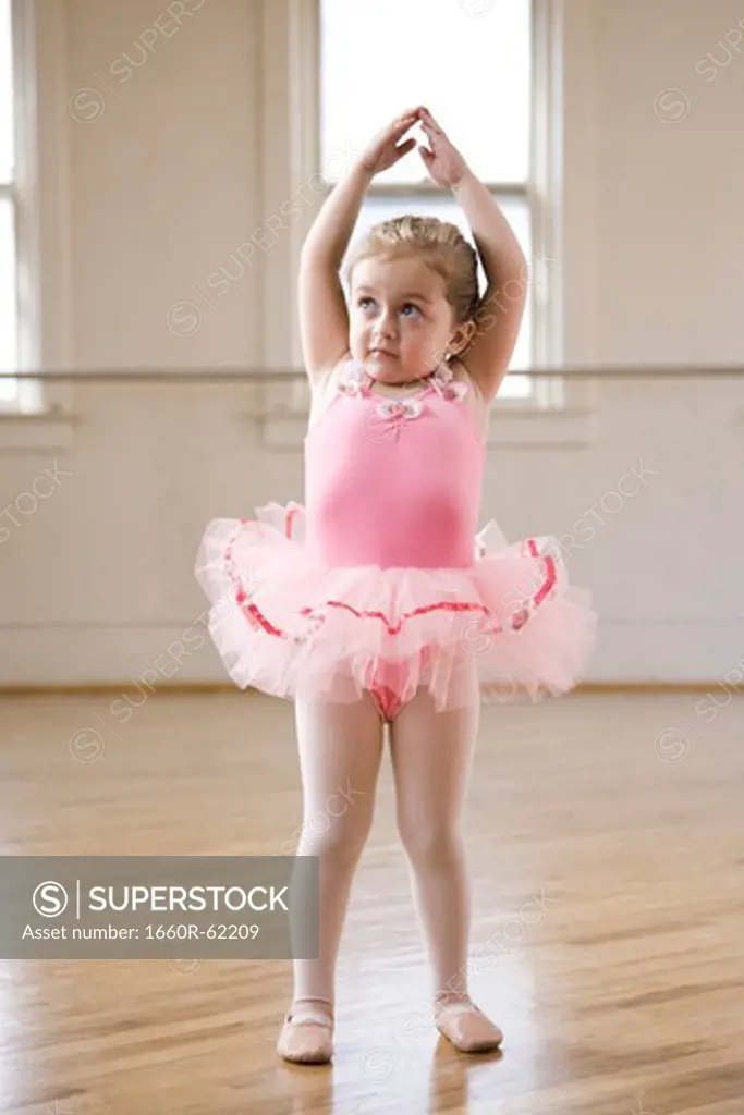 Girl (2-3) practicing ballet in studio