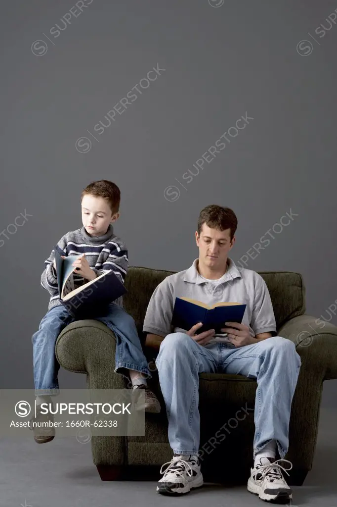 Father and son reading on armchair