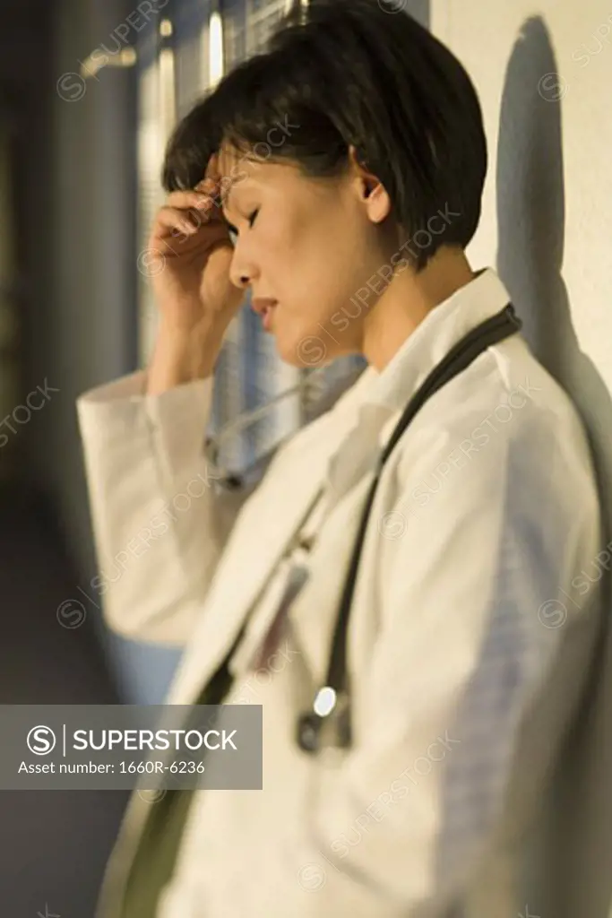 Profile of a female doctor with her hand on her forehead