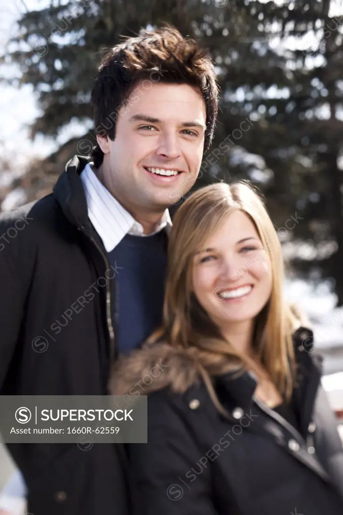Couple smiling standing near fence