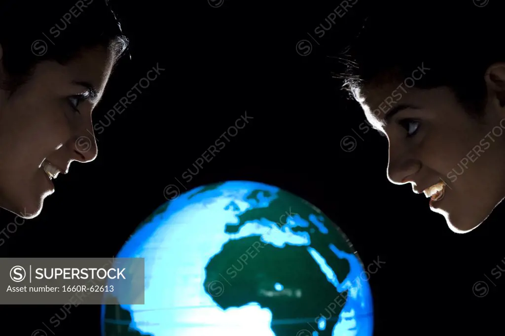 Sisters studying earth globe