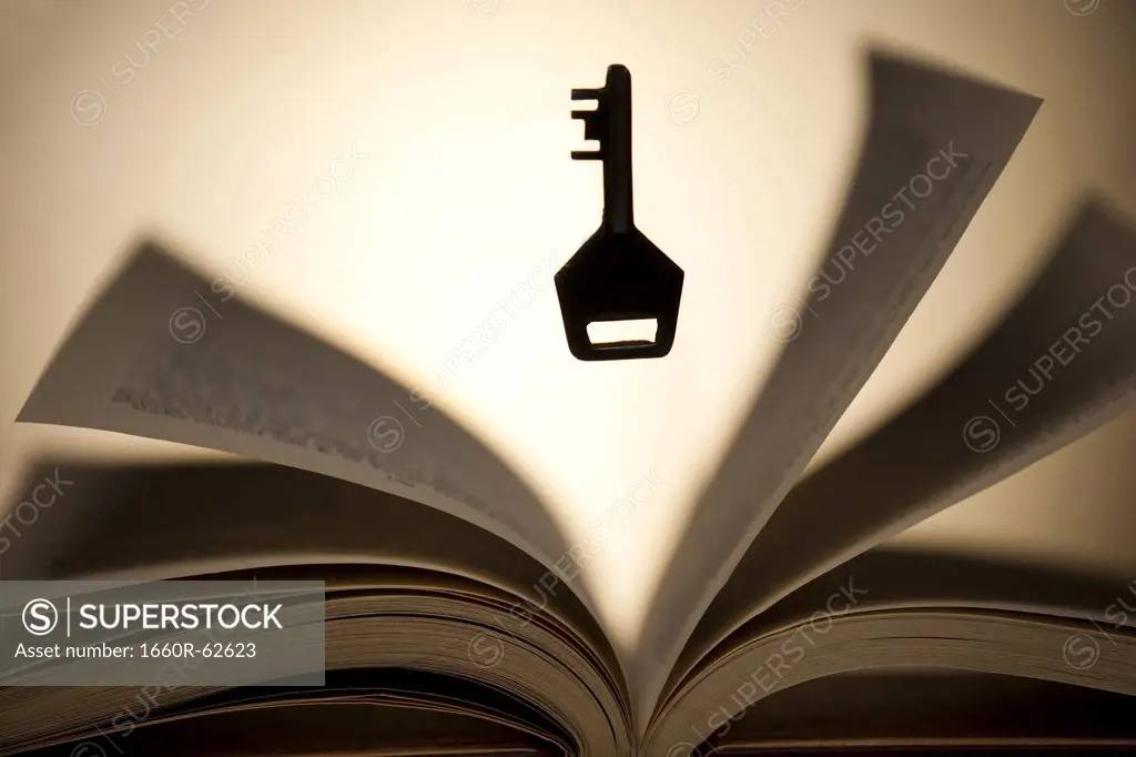 Key hovering above open book