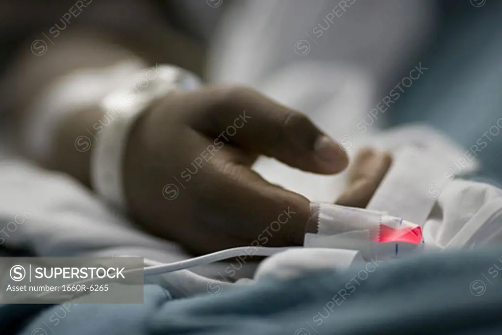 Close-up of a patient's hand in a hospital bed