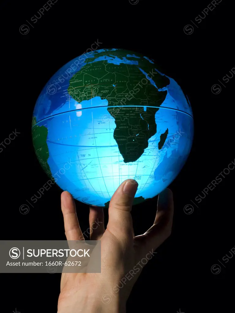 Hand holding earth globe on fingertips