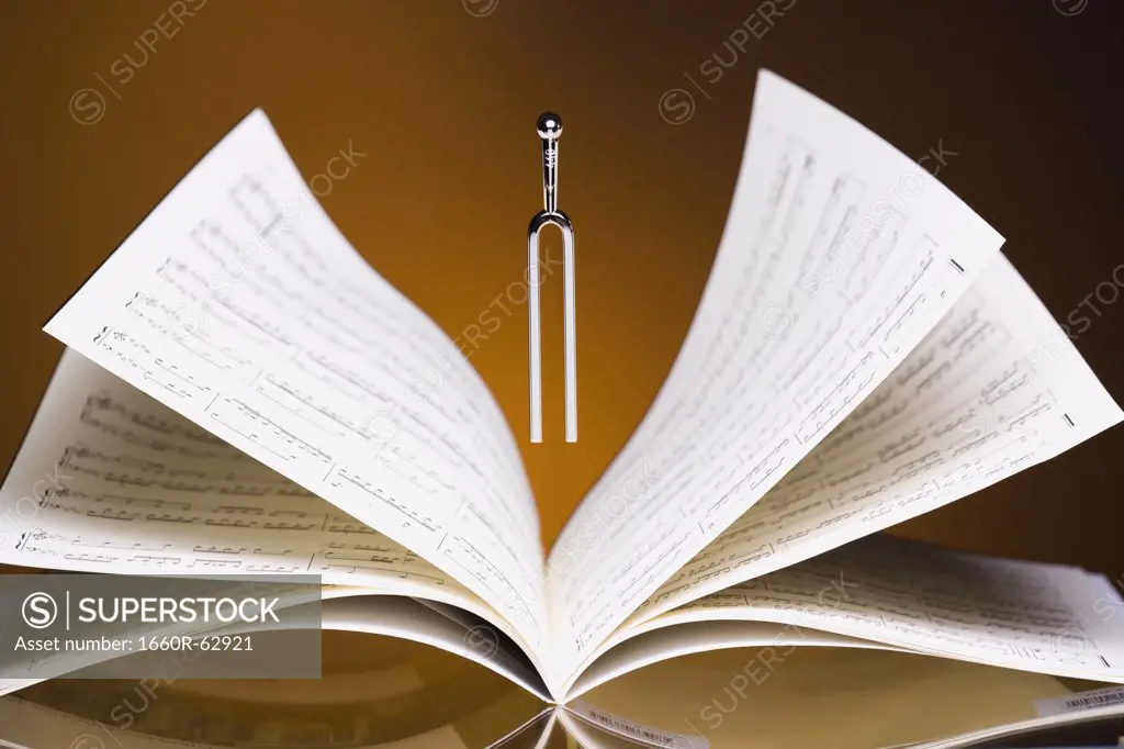 Tuning fork hovering over musical score
