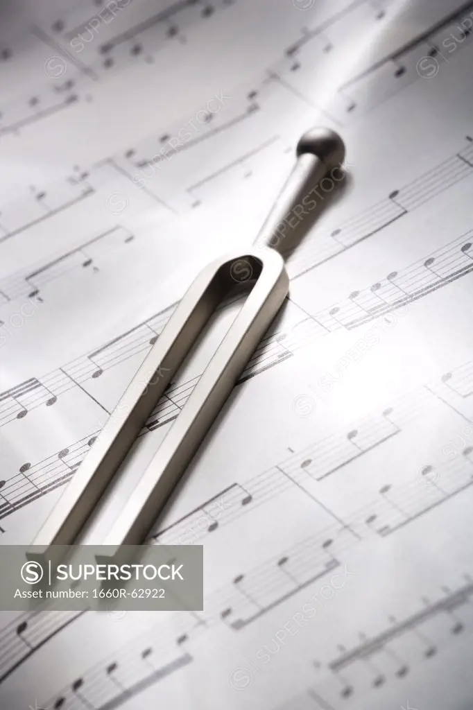 Tuning fork resting on musical score