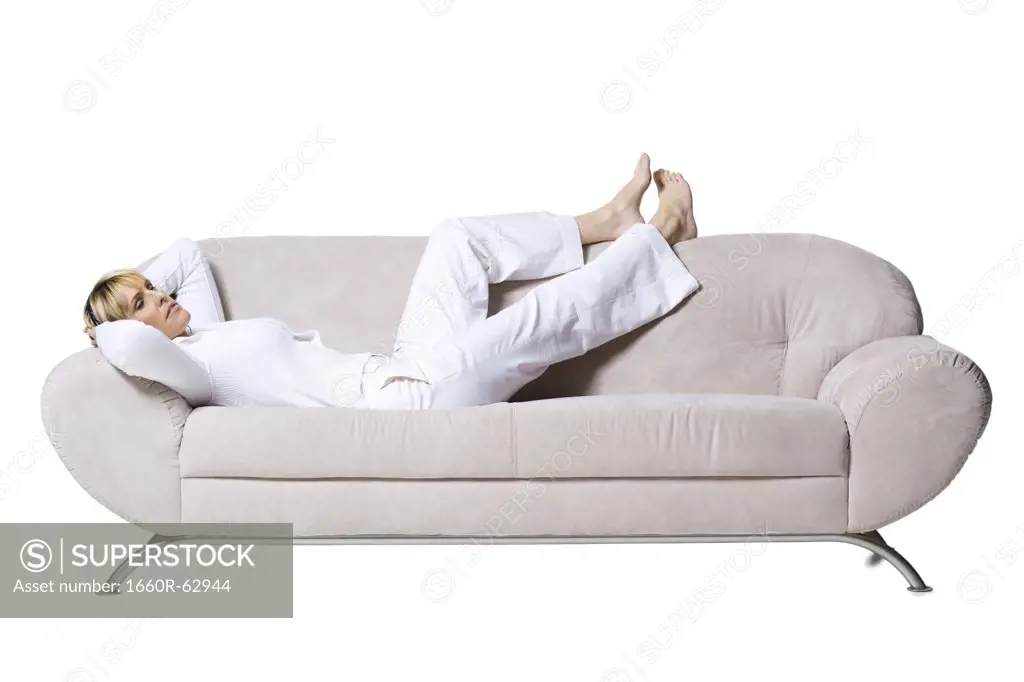 Woman smiling resting on couch with headphones