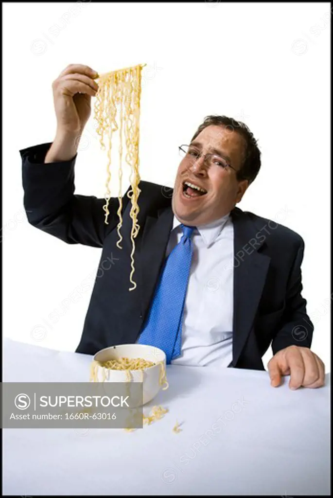 Businessman awkwardly eating noodles