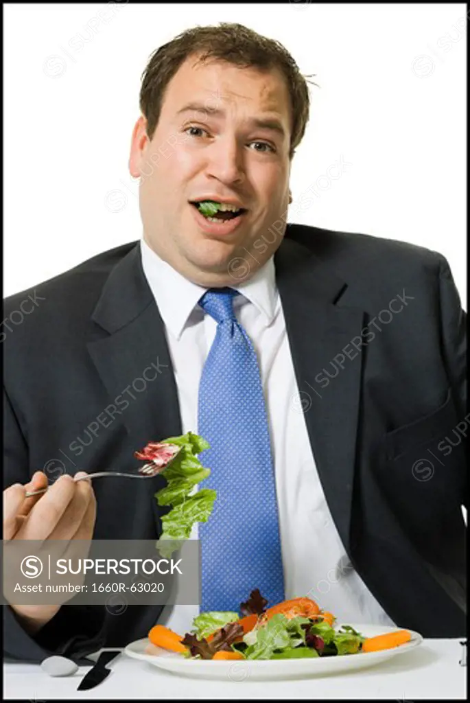 Overweight businessman eating a salad lunch