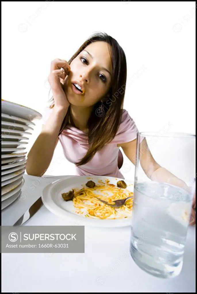 Woman engorging herself on spaghetti