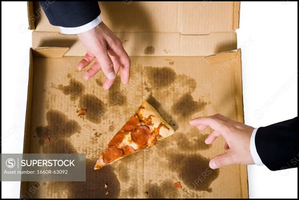 Two hands reaching for last slice of pizza