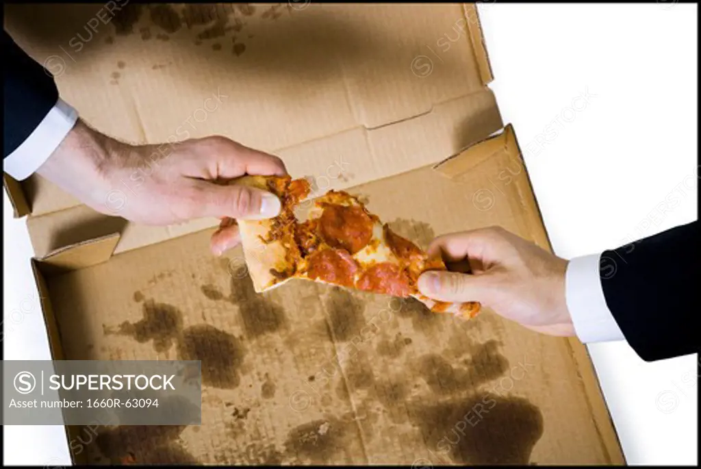 Two hands reaching for last slice of pizza
