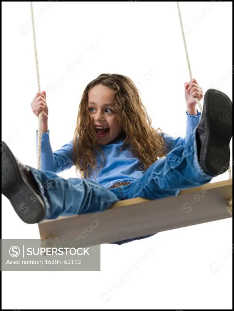 Young girl playing on a swing