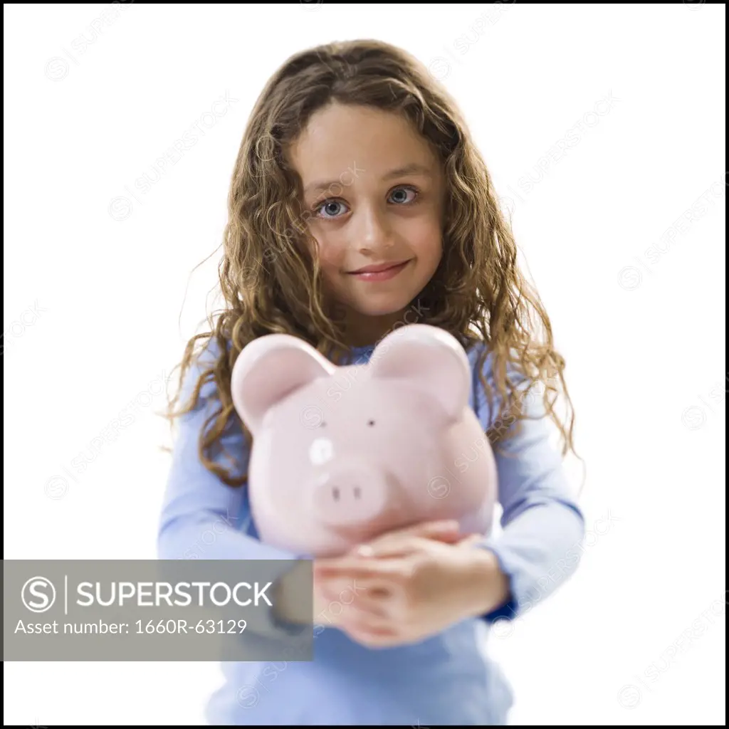Young girl hugging piggy bank