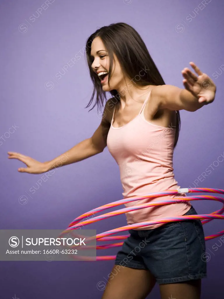 Woman dancing and playing with hula hoops