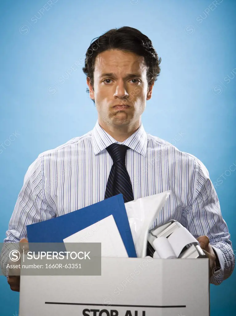 Portrait of a businessman holding a cardboard box full of belongings