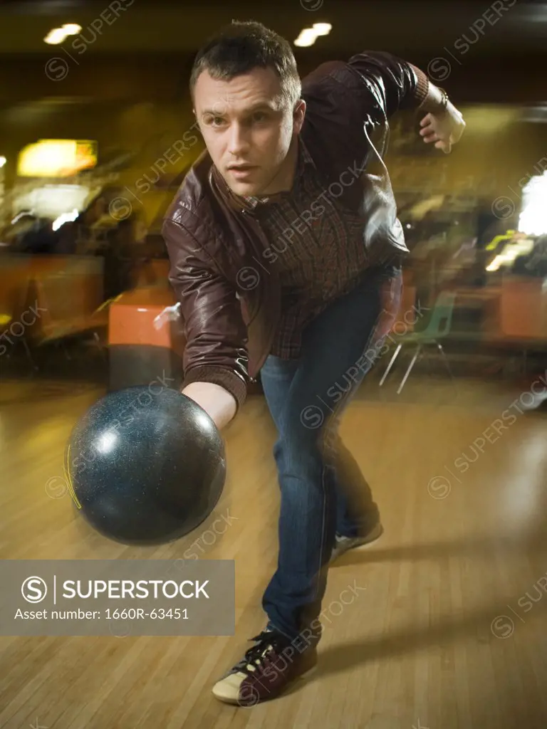 Young man bowling in a bowling alley