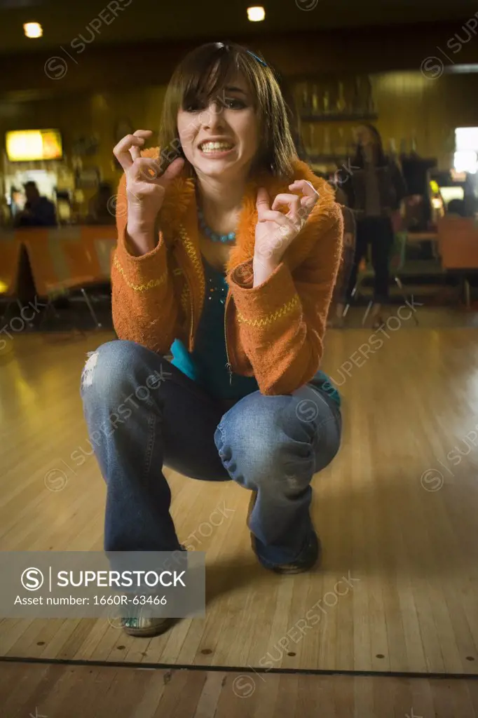Teenage girl making a face in a bowling alley