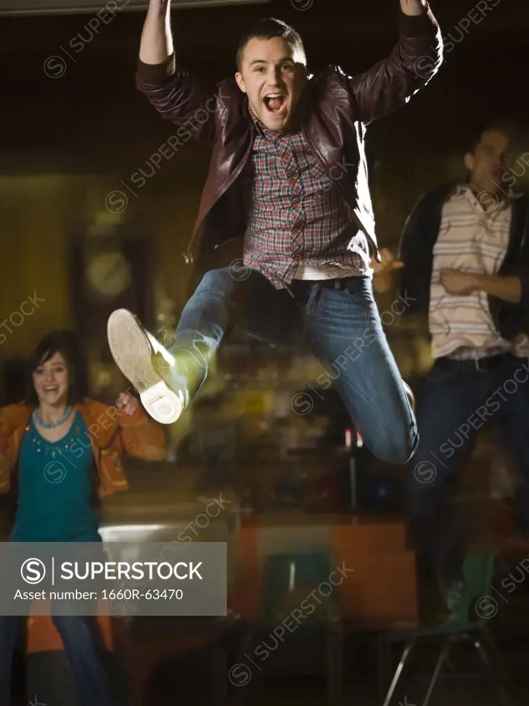 Young man jumping in excitement in a bowling alley