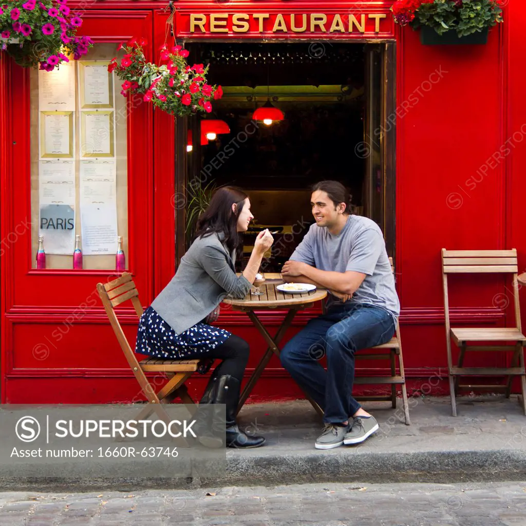 France, Paris, Young couple sitting in sidewalk cafe