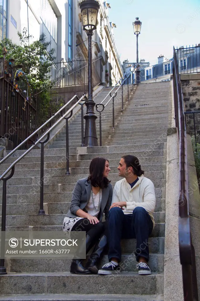 France, Paris, Young couple sitting on steps