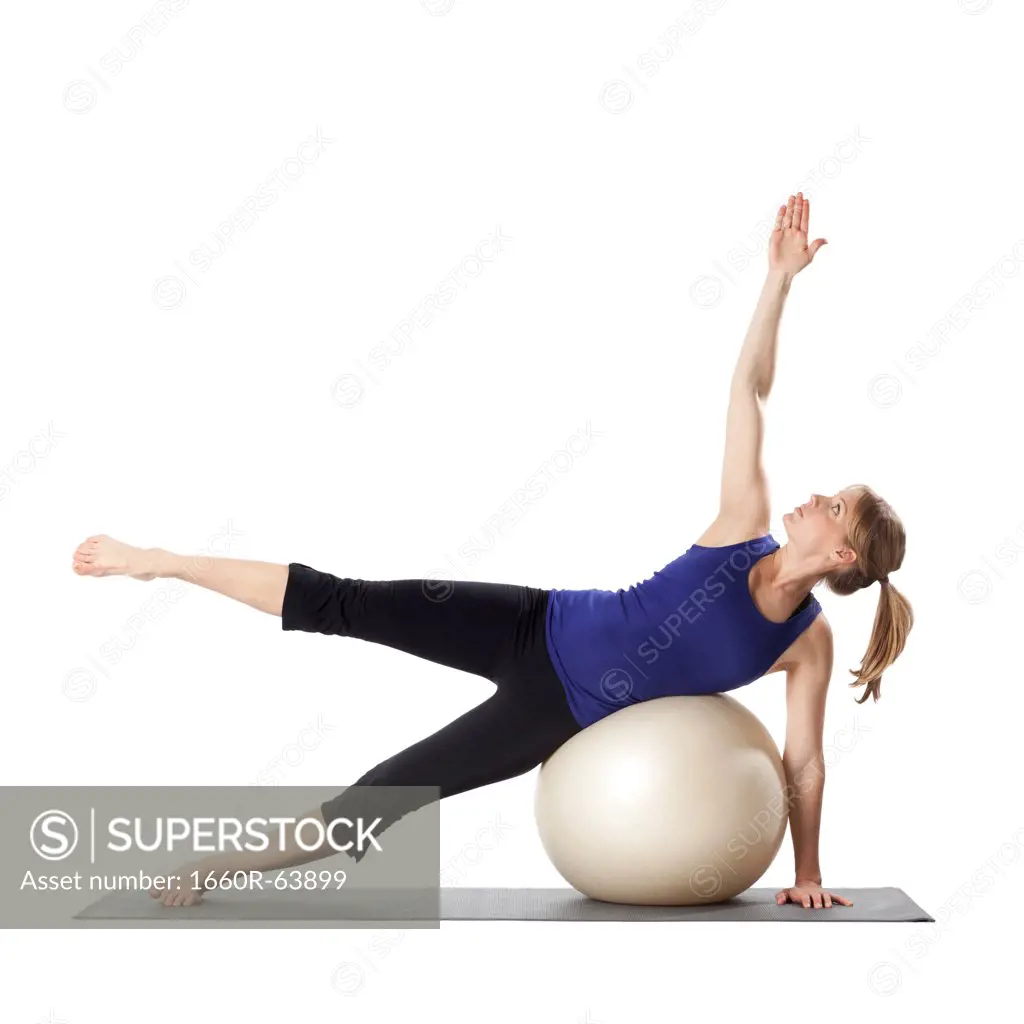 Young pregnant woman exercising with fitness ball,  studio shot