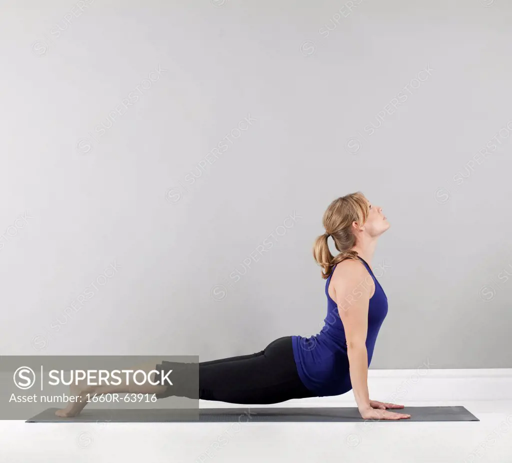 Young pregnant woman practicing yoga,  studio shot