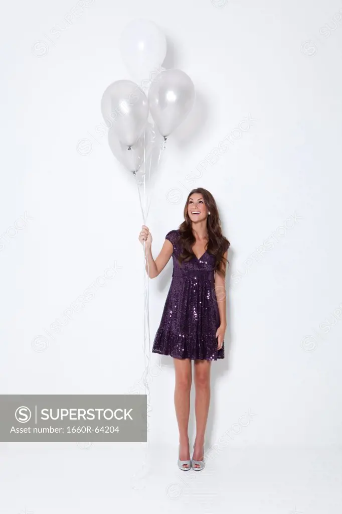 Young woman holding balloons at party