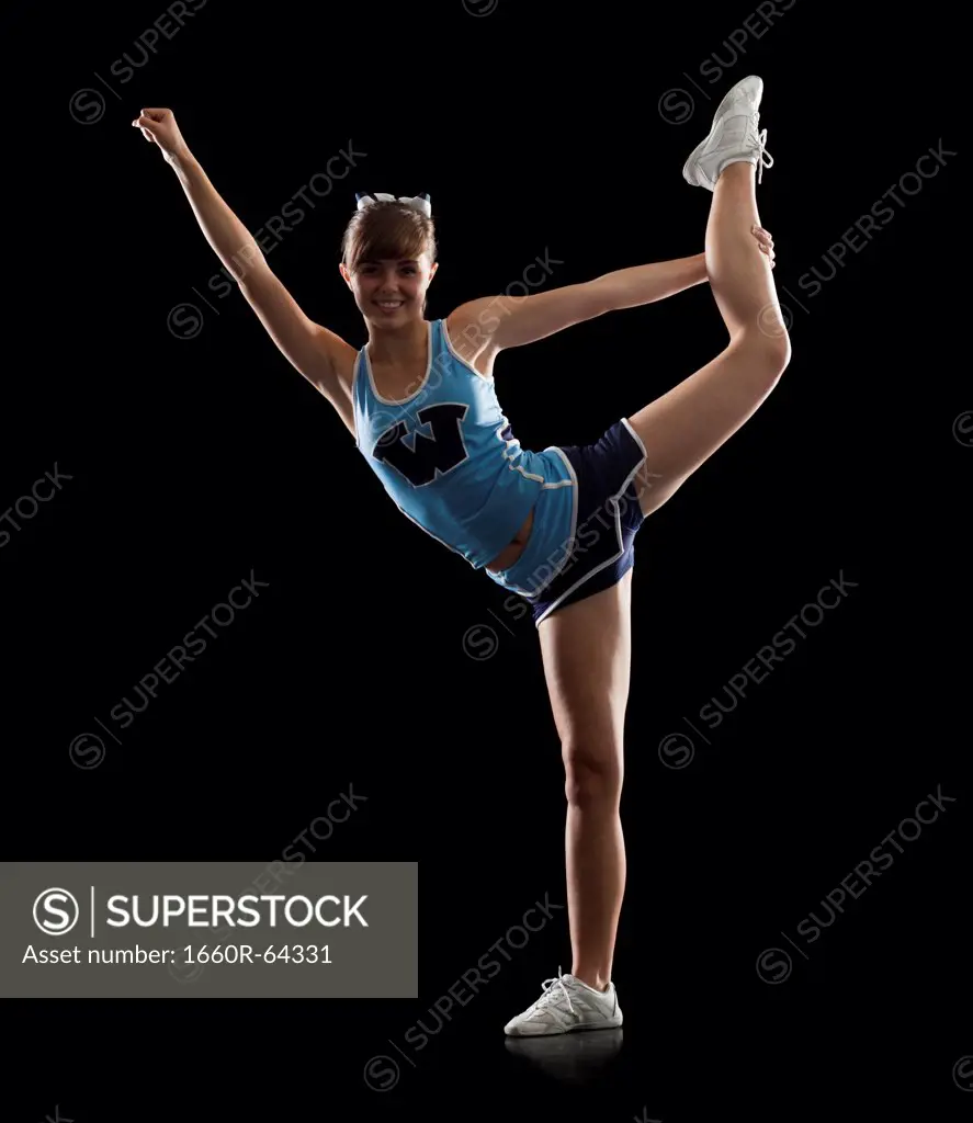 Portrait of teenage cheerleader girl (16-17) stretching