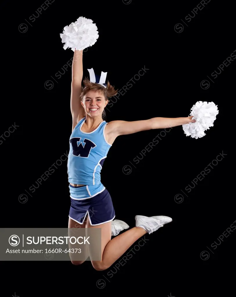 Studio shot of cheerleader (16-17) jumping