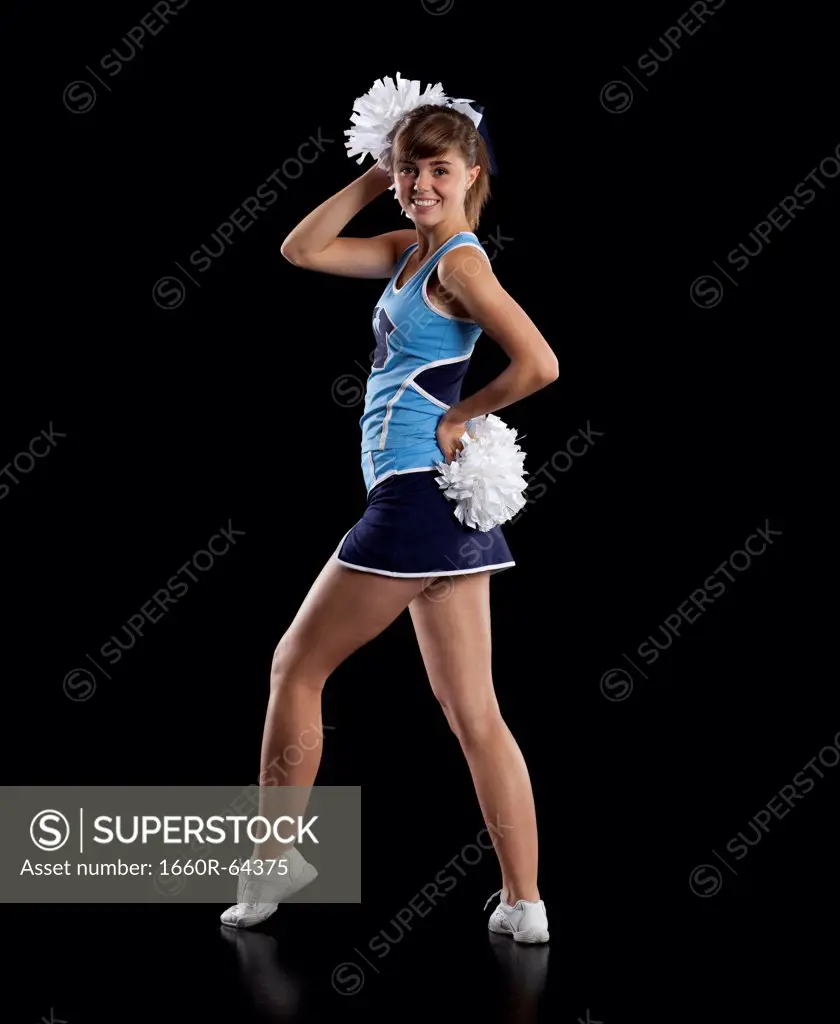 Studio shot of cheerleader (16-17) striking pose