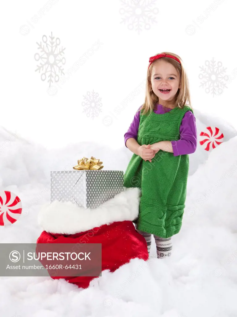 Studio shot of girl (18-23 months) with Christmas gifts