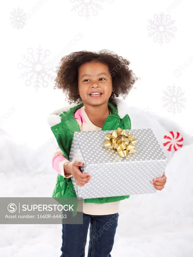 Girl (4-5) holding christmas gift