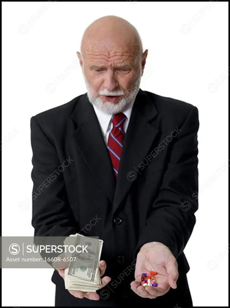 Close-up of a businessman holding American dollar bills and pills