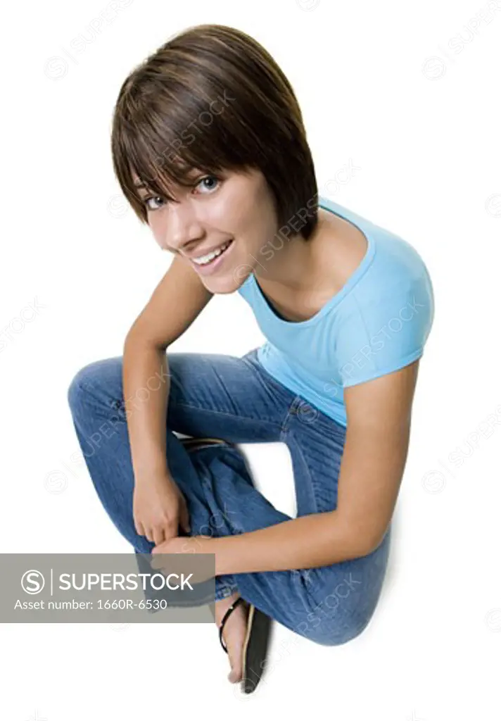 High angle view of a teenage girl sitting on the floor