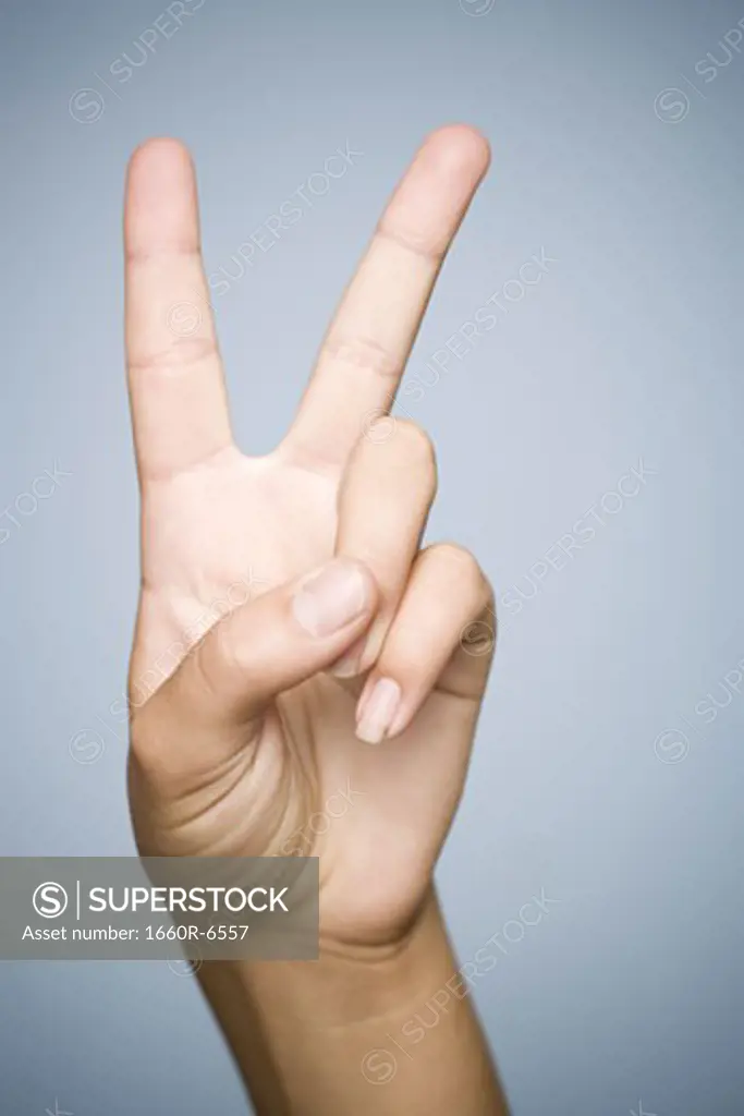 Close-up of a person's hand showing a peace sign; sign language for "peace," and the number two