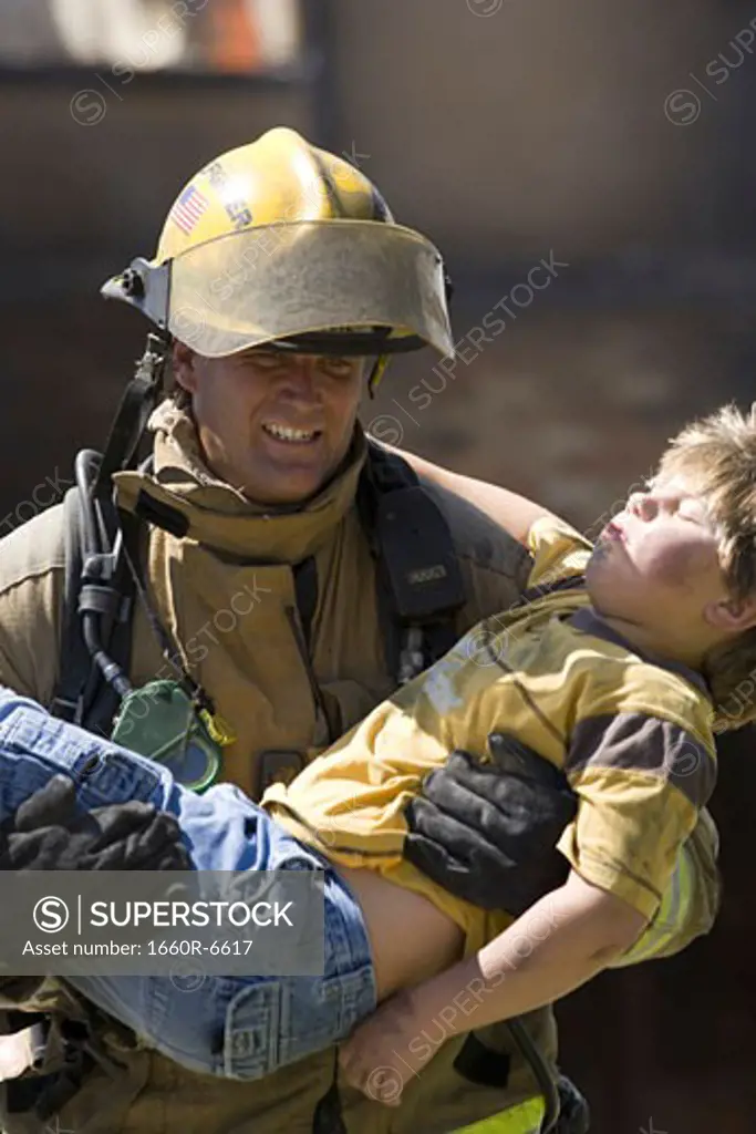 Firefighter carrying a wounded boy