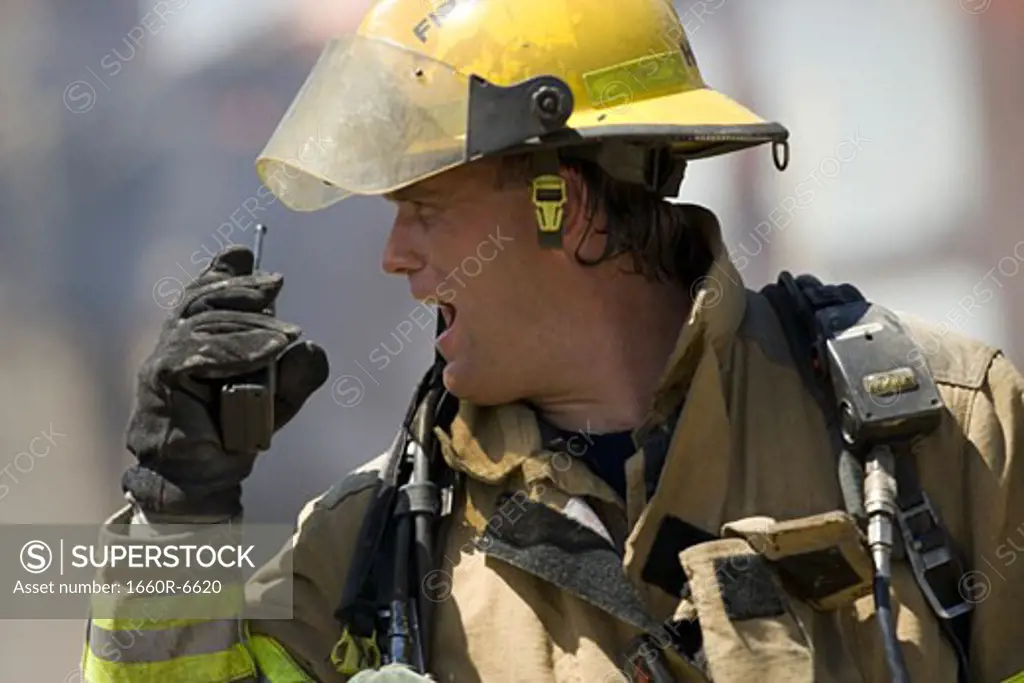 Close-up of a firefighter holding a walkie-talkie