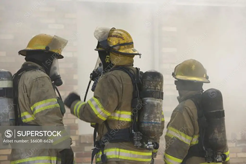 Three firefighters in firefighting gear