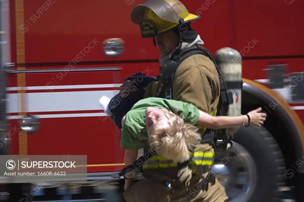 Profile of a firefighter carrying a boy